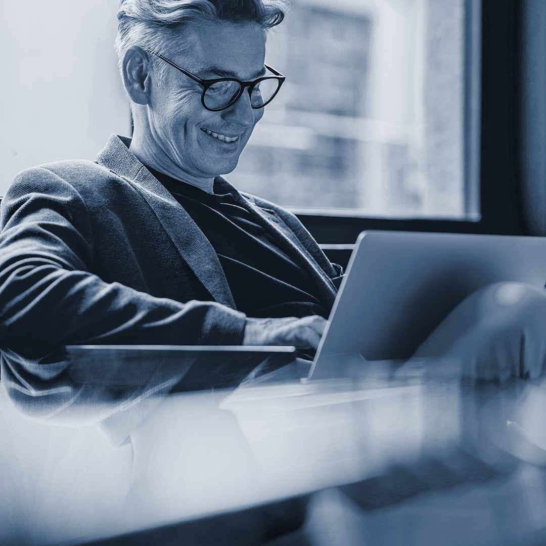 man smiling at his laptop