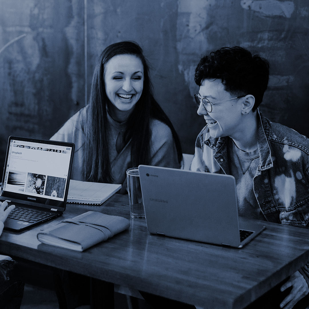 Two people laughing while working